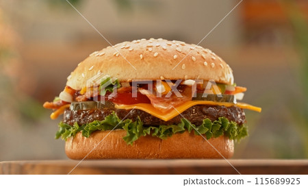 Delicious cheeseburger with cheese, lettuce, tomato, red onion and bun. Delicious cheeseburger with cheese, lettuce, tomato, red onion and bun. 115689925