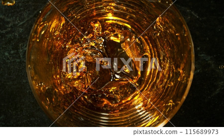 Closeup of ice cube inside glass of whiskey. Closeup of ice cube inside glass of whiskey. 115689973
