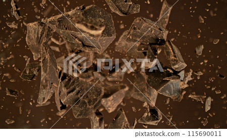 Freeze motion of flying group of raw chocolate pieces. Freeze motion of flying group of raw chocolate pieces. 115690011