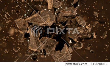 Freeze motion of flying group of raw chocolate pieces. Freeze motion of flying group of raw chocolate pieces. 115690012