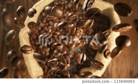 Freeze motion of flying coffee beans into jute sack. 115690063