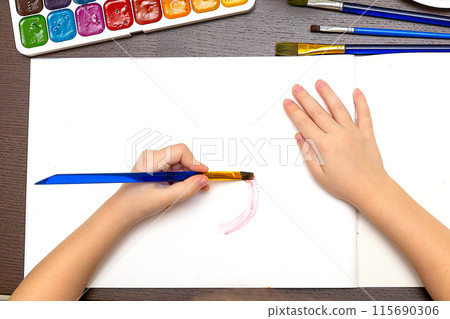 small child draws with pastel crayons on white table. fathers day 115690306