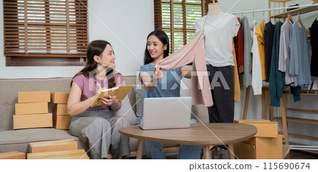 Lesbian Couple Running Online Clothing Business from Home, Packing Order and Managing Inventory Together 115690674