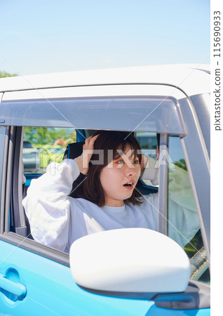 Woman sitting in a car and holding her head Woman sitting in a car and holding her head 115690933