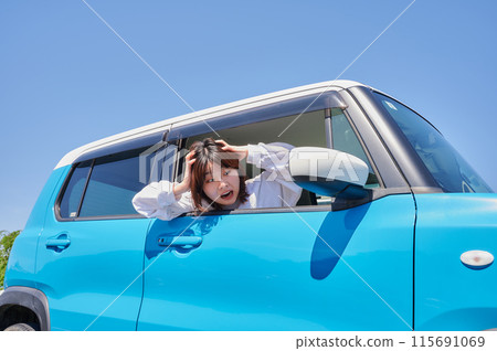 Woman sitting in a car and holding her head Woman sitting in a car and holding her head 115691069