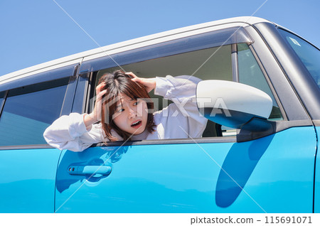 Woman sitting in a car and holding her head Woman sitting in a car and holding her head 115691071