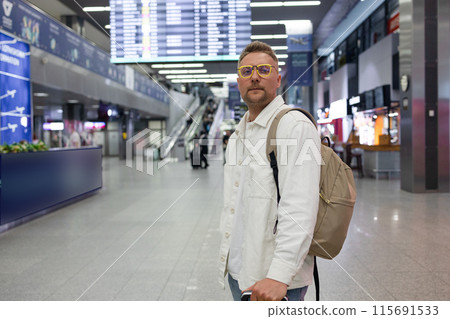 Young Caucasian male passenger in stylish casual clothes using smartphone and laptop keyboard, sit has training online meeting on laptop computer in airline lounge wait transit international airport Young Caucasian male passenger in stylish casual clothes using smartphone and laptop keyboard, sit has training online meeting on laptop computer in airline lounge wait transit international airport 115691533