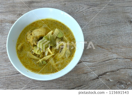 spicy boiled slice fresh bamboo shoot with chicken topping stink bean in coconut milk curry soup on bowl 115691543