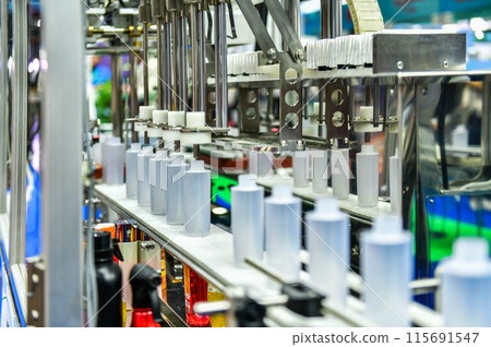 White plastic bottles in a conveyor belt on a high quality automatic vertical filling machine. in the factory production line White plastic bottles in a conveyor belt on a high quality automatic vertical filling machine. in the factory production line 115691547