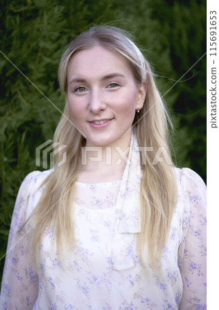 portrait of a young blonde woman in a pastel chiffon dress 115691653