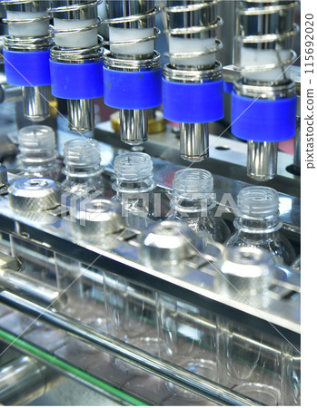 Plastic bottles in a conveyor belt on a high quality automatic vertical filling machine. in the factory production line 115692020