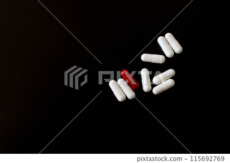 Pills. Medical pills and capsules. Red capsule. Isolated on a black background. An allergy pill, antibiotics, supplements. Medicine, healthcare concept. Virus(viral), flu diseases. High quality photo Pills. Medical pills and capsules. Red capsule. Isolated on a black background. An allergy pill, antibiotics, supplements. Medicine, healthcare concept. Virus(viral), flu diseases. High quality photo 115692769