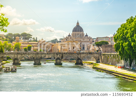 A view of the Tiber River in Rome, with a bridge in the foreground and St. Peters Basilica in the background. 115693452