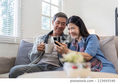 Elderly Couple Enjoying Modern Technology, Shopping and Social Media Together on Smartphone at Home Elderly Couple Enjoying Modern Technology, Shopping and Social Media Together on Smartphone at Home 115693540