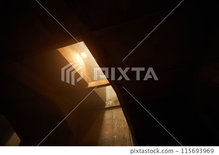 Dark concrete room with warm light Dark concrete room with warm light 115693969