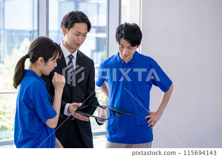 商人在平板電腦上向男性和女性護理人員解釋該系統 115694143