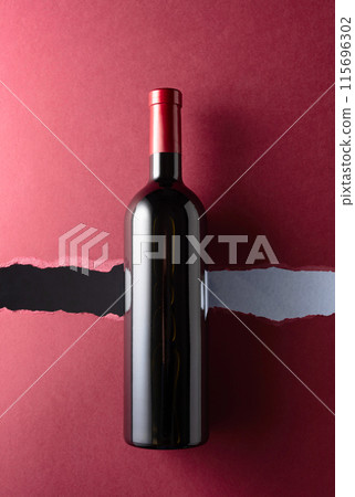 Bottle of red wine on a dark red background. Bottle of red wine on a dark red background. 115696302