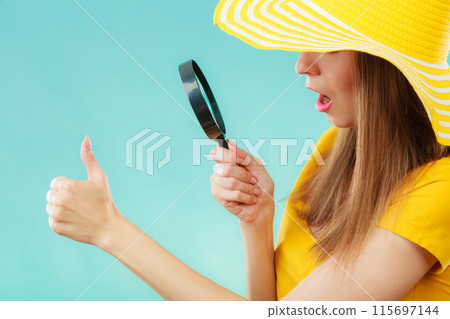 girl holding magnifying glass looking on fingernails girl holding magnifying glass looking on fingernails 115697144