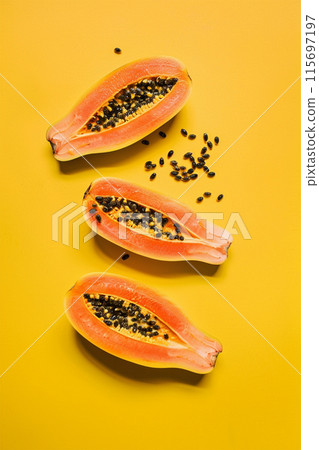 Cuted papaya slices on yellow background, top view Cuted papaya slices on yellow background, top view 115697197