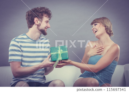 Young man giving woman gift box Young man giving woman gift box 115697341