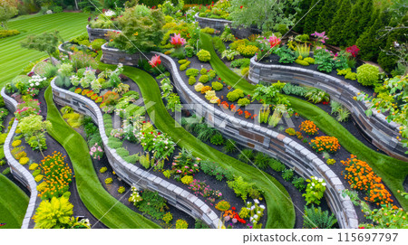Aerial view of terraced home garden and stone retaining walls, landscape design of luxury house back yard. Beautiful flowers at backyard. Concept of landscaping, nature 115697797