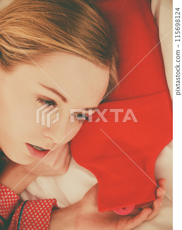 Woman sleeping with warm red hot water bottle Woman sleeping with warm red hot water bottle 115698124