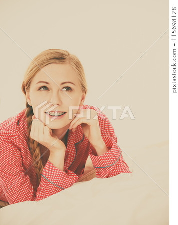 Smiling woman lying in bed Smiling woman lying in bed 115698128