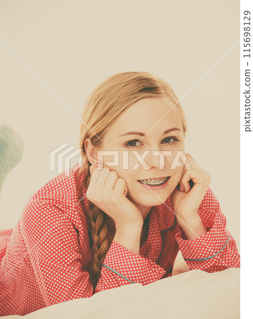 Smiling woman lying in bed Smiling woman lying in bed 115698129