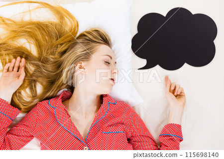 Young woman lying on bed wearing pajamas Young woman lying on bed wearing pajamas 115698140