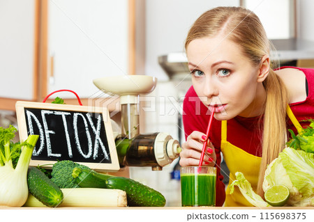 Woman in kitchen having green detox vegetables 115698375
