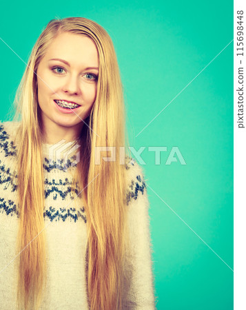 Happy woman showing her braces on teeth Happy woman showing her braces on teeth 115698448