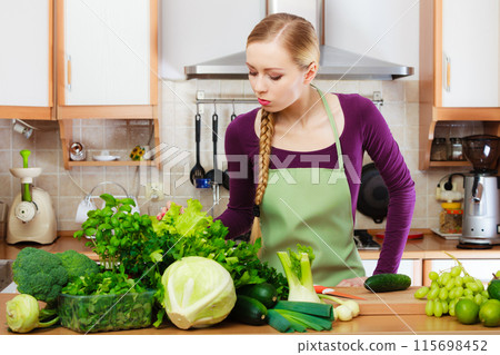 Woman housewife in kitchen with green vegetables Woman housewife in kitchen with green vegetables 115698452