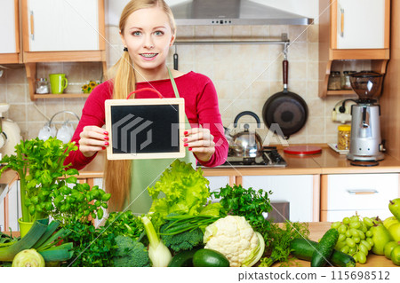 Woman having green vegetables holding board 115698512