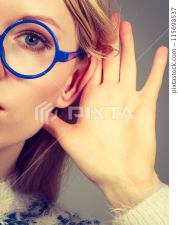 Woman listening carefully with hand close to ear 115698537