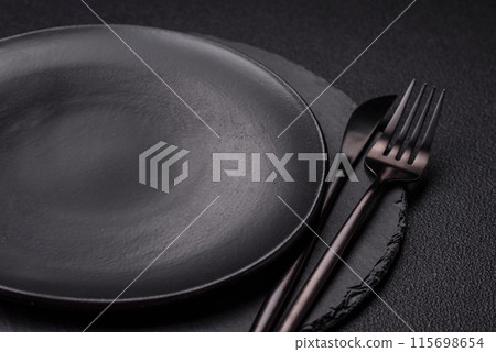 Empty round slate plate for template on the black background 115698654