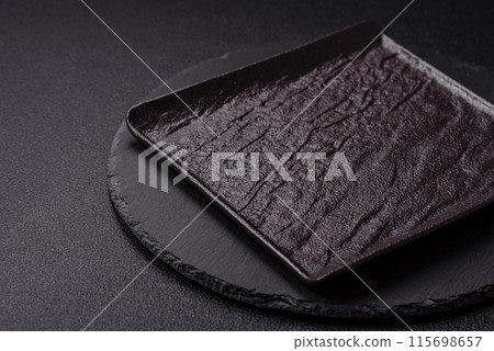 Empty round slate plate for template on the black background 115698657