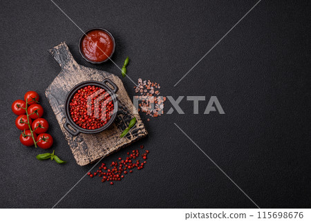 Spice, allspice peas in red or pink color in a bowl on a black concrete background Spice, allspice peas in red or pink color in a bowl on a black concrete background 115698676