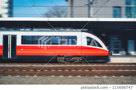 High-speed passenger train moving at railway station at sunset High-speed passenger train moving at railway station at sunset 115698747