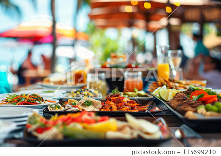 Beachside dining setup featuring a variety of food platters under a shaded canopy 115699210