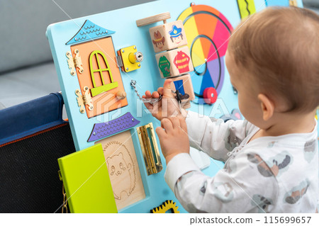Baby plays with unlocking the lock with a small key Baby plays with unlocking the lock with a small key 115699657