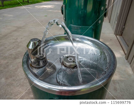 Closeup of outdoor water fountain at state park water pours from spout 115699776