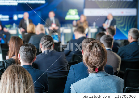 Business conference with attendees listening to speakers on stage Business conference with attendees listening to speakers on stage 115700006
