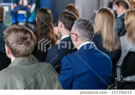 Business professionals attentively listening at a corporate event 115700015