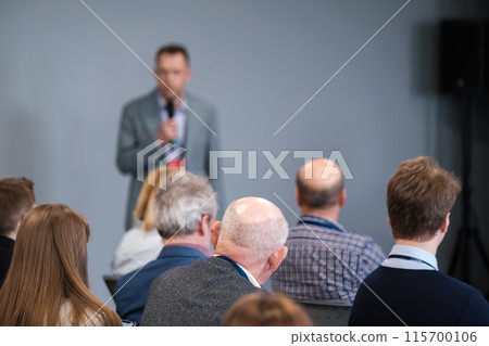 Speaker presents at business conference to attentive audience 115700106