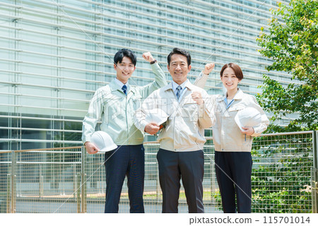 Workers posing in celebration outdoors 115701014