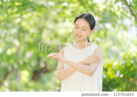 Woman applying sunscreen on arm 115701824