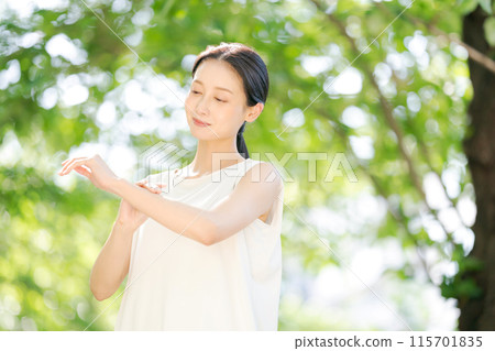 Woman applying sunscreen on arm 115701835