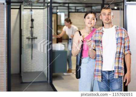 Husband and wife choosing bathroom accessories together at hardware store 115702051