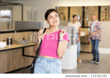 Young asian girl in hardware store choosing bathroom accessories 115702191