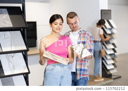 Couple of man and woman choose tiles in store 115702212